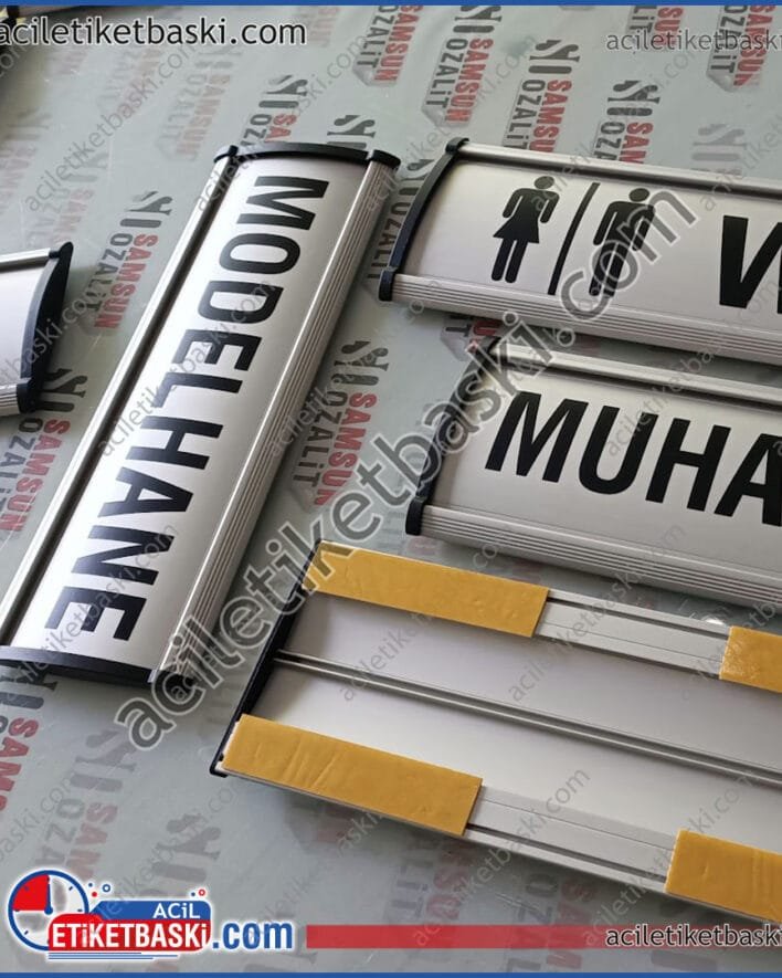 kapı isimliği, alüminyum, bombeli kapı isimliği, gerçek alüminyum, üzeri baskılı, kenarları plastik, arkasında bant var, 9x25cm standart ürün, acil üretim, tasarım desteği