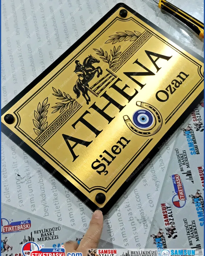 25x35 kapı tabelası, fırçalı altın tabela, siyah kompozit tabela, dekoratif vidalı tabela, dış mekan metal tabela, şık kapı isimliği, tabela imalatı samsun, alüminyum kompozit tabela baskı